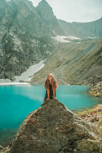 Woman standing on rock by mountain