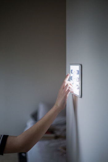Cropped image of boy using digital tablet mounted on wall at home