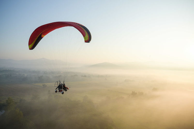 Person paragliding against sky