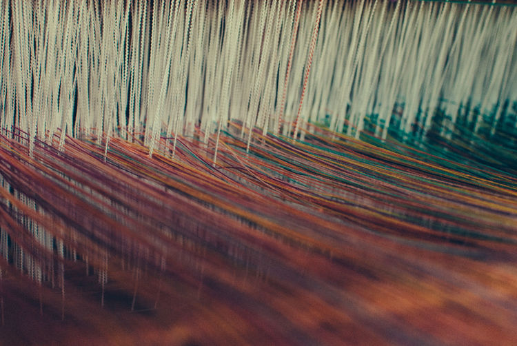 Close-up of threads on loom in textile factory