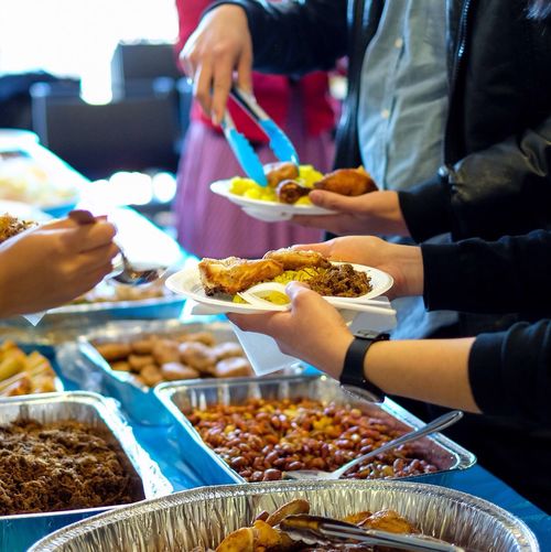 People serving indonesian food on table during birthday party