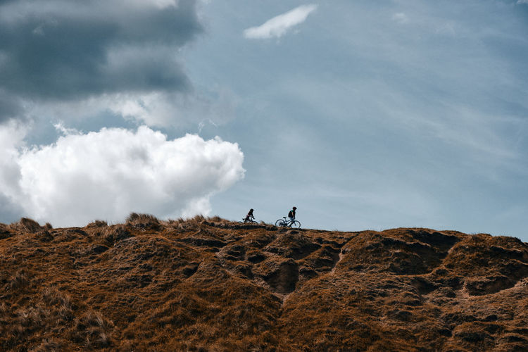 Rear view of man walking on mountain against sky