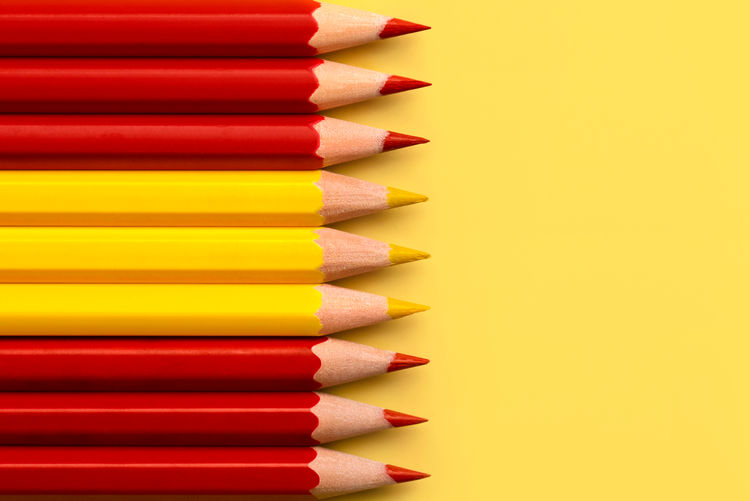 Close-up of colored pencils on yellow background