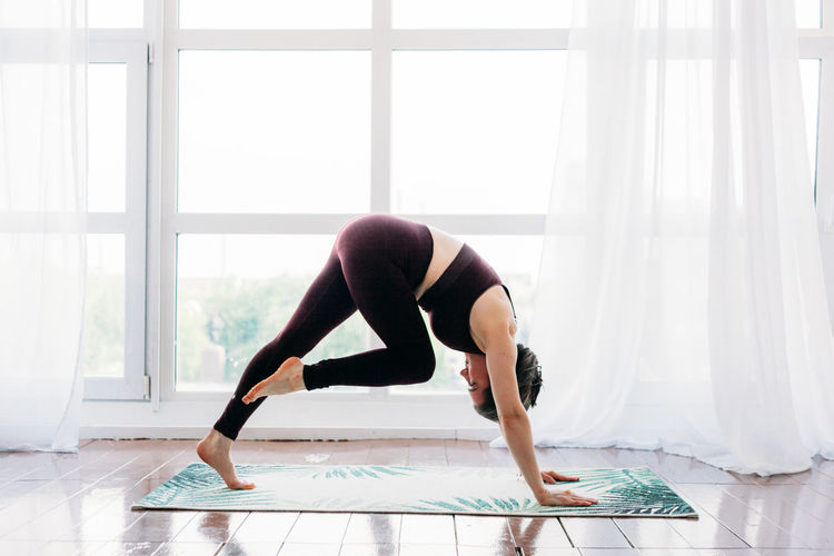 Full length of woman exercising at home