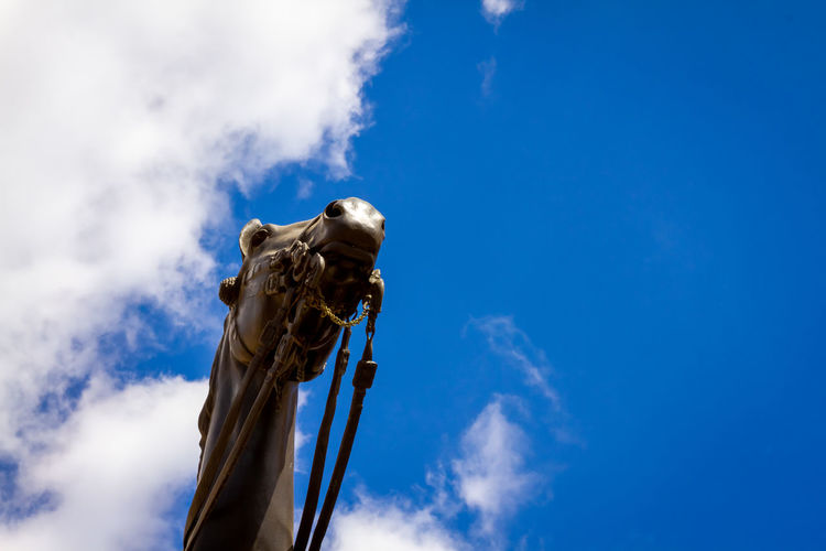 Low angle view of statue against blue sky