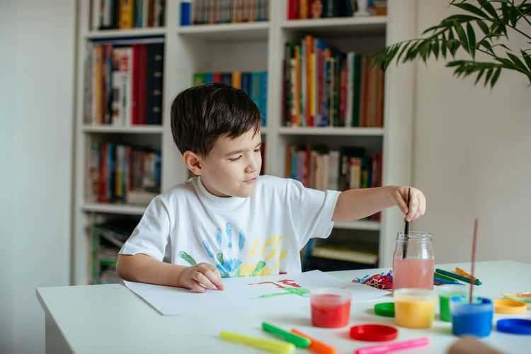 Boy doing painting while sitting at home