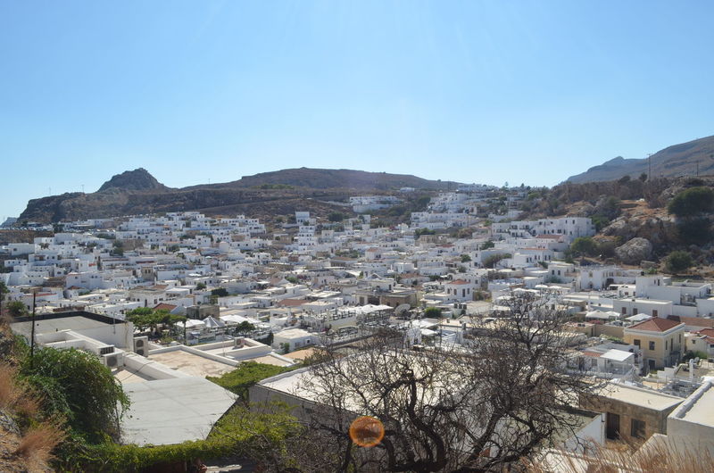 Lindos by mountains against clear blue sky