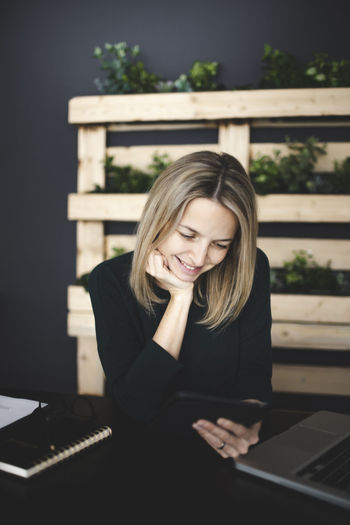 Portrait of smiling young woman using mobile phone