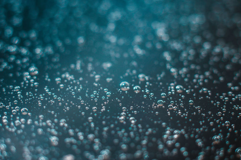 Dark blue background of air bubbles on the water surface. close-up shot of air bubbles in liquid.