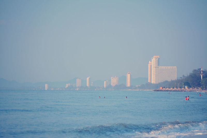 Sea and buildings against clear sky