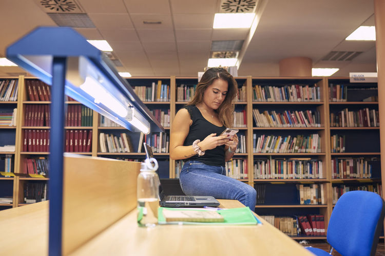 Portrait of a girl making a video call in a library