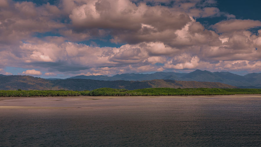 Scenic view of land and mountains against sky