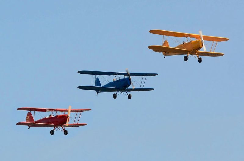 Three biplanes flying in sky