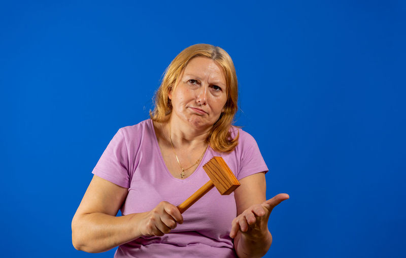 Low angle portrait of woman against blue background