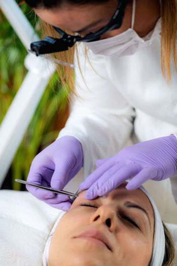 Microblading eyebrows in beauty salon.