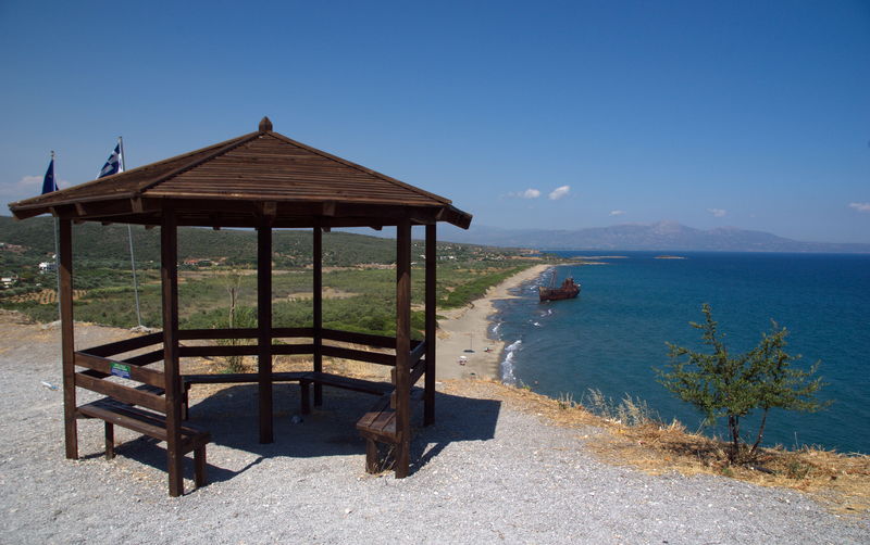 Gazebo by sea against clear blue sky