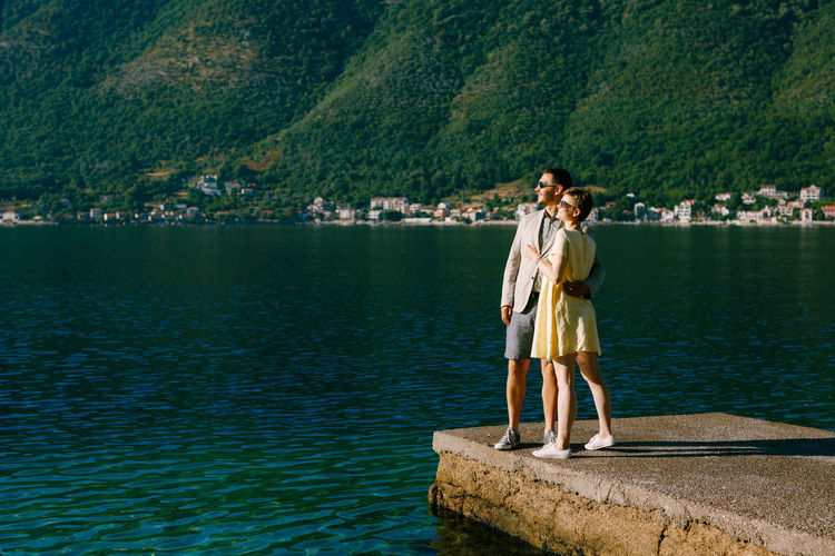 Couple standing at pier by lake