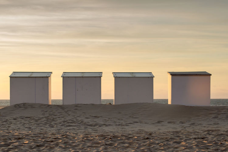 Beach cabins in a row at sunset