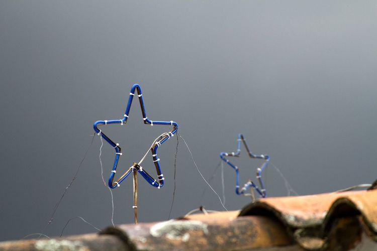 Blue star decorations on an orange roof with a gray, foggy sky backdrop