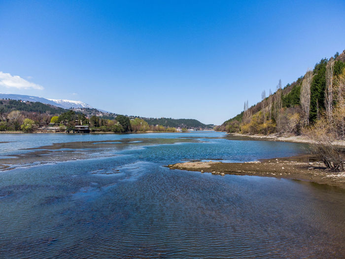 Scenic view of river against clear blue sky