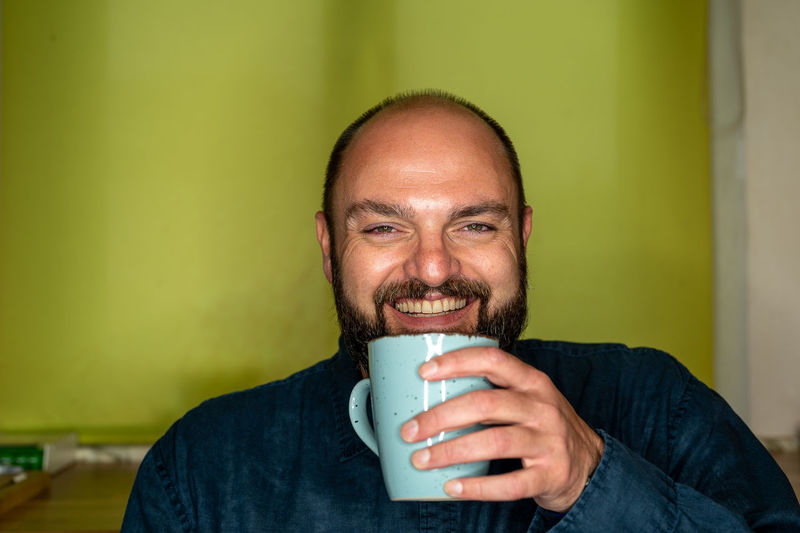 Portrait of man drinking coffee at home
