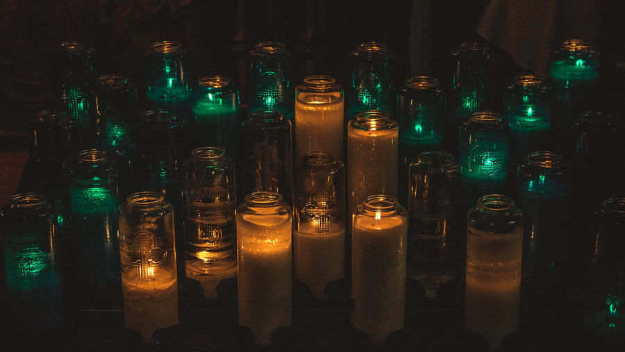 Close-up of illuminated candles in glass jars