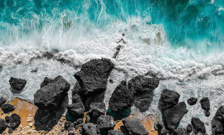 Panoramic shot of sea waves splashing on rocks