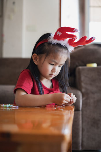 Cute girl making decoration on table