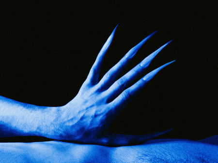CLOSE-UP OF HANDS OVER BLUE BACKGROUND