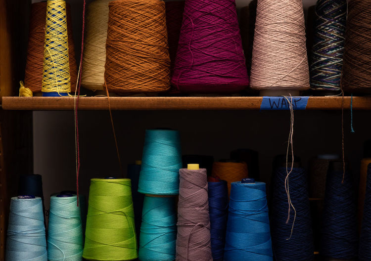 Full frame shot of multi colored spools on shelf