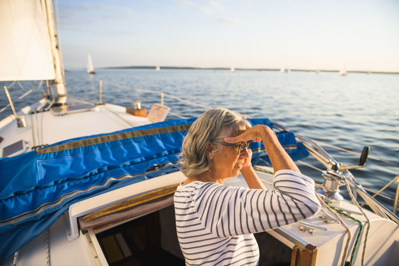 Middle age woman enjoying summer sail during golden hour