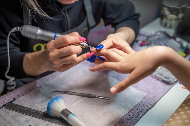 The procedure of a hardware manicure for a girl in a close-up in a beauty salon