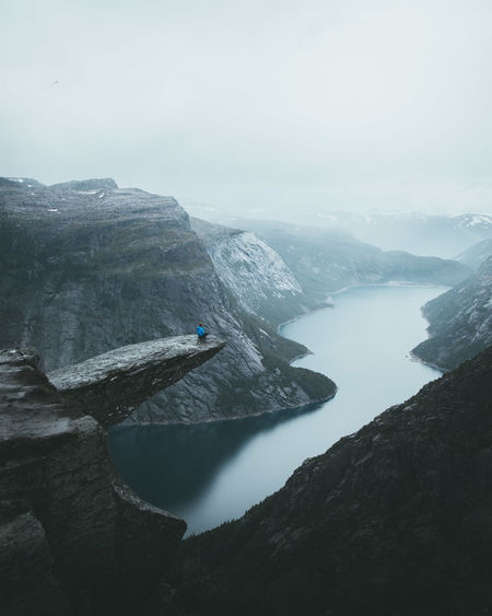 Men sitting on rock formation over river