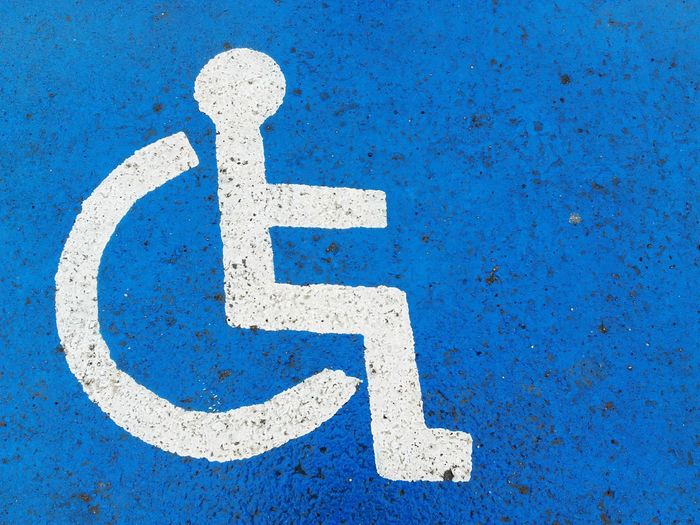 Close-up of wheelchair access sign on road