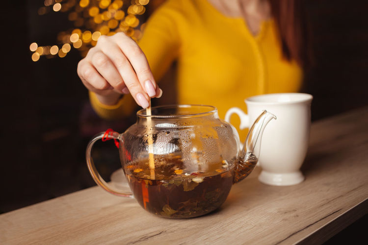 Woman brews tea, delicious aroma, appetizing. white porcelain cup, drink, tea shop. 