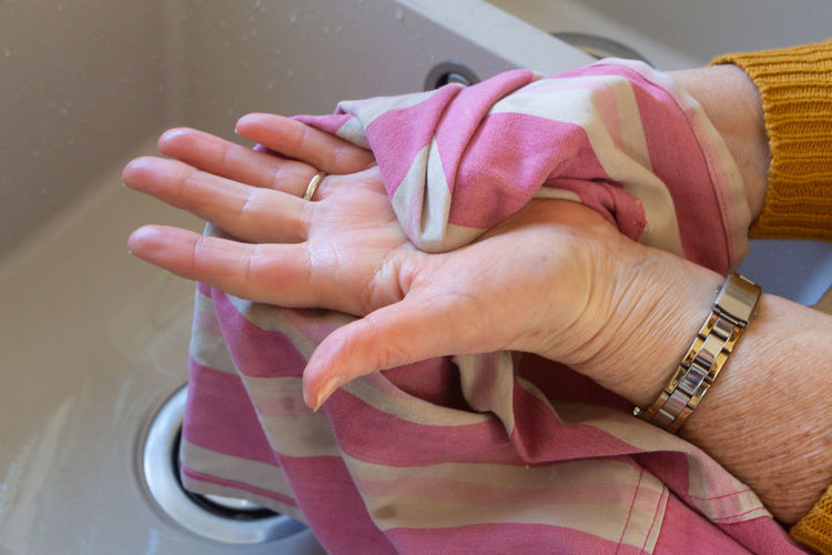 Close-up of woman drying hand with textile