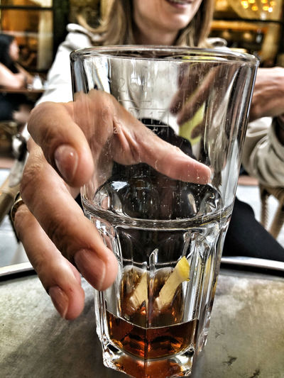 Close-up of hand holding glass of drink