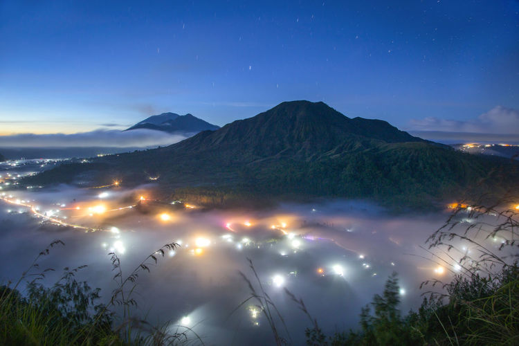 Scenic view of illuminated mountains against sky at night