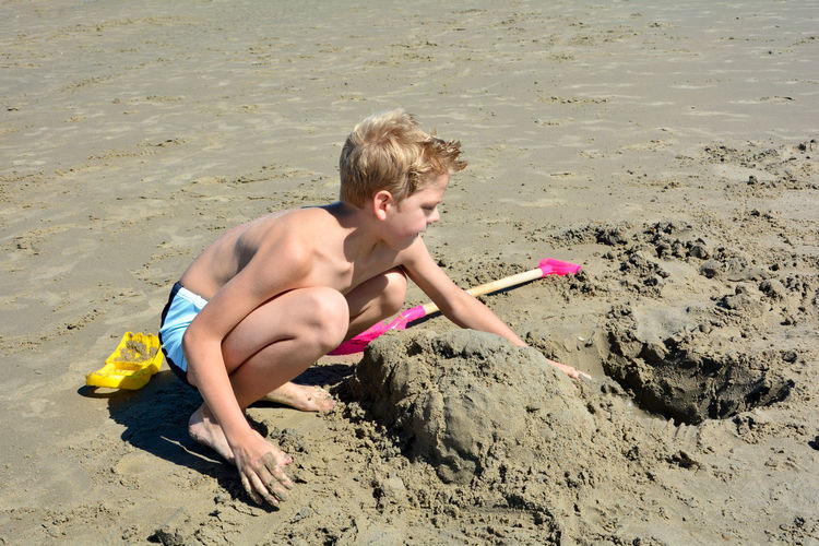 High angle view of shirtless boy on beach