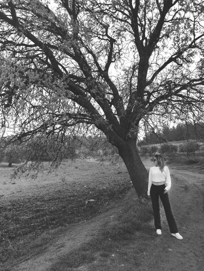 Woman standing by tree on field