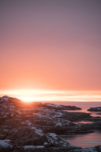 Scenic view of snow covered landscape against sky during sunset