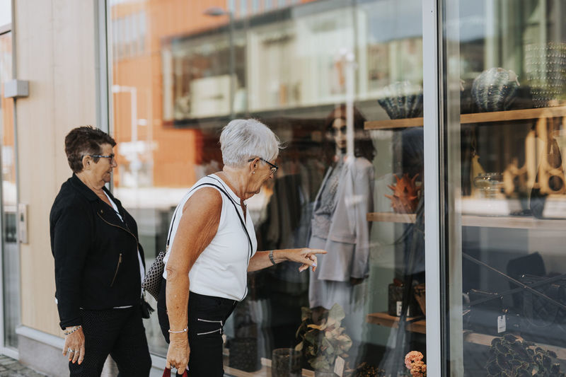 Senior women looking at shop window