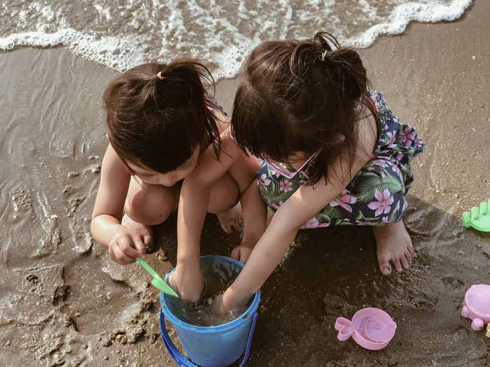 High angle view of siblings playing at beach