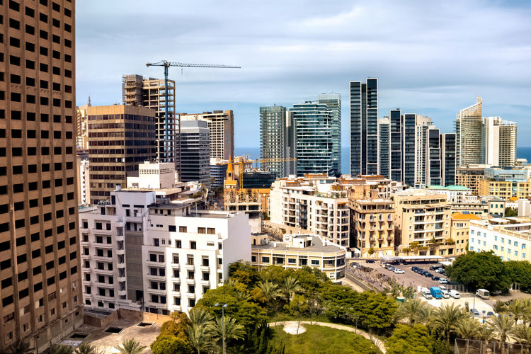 Aerial view of buildings in city against sky