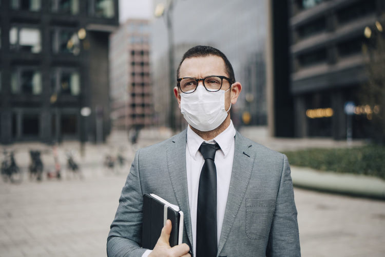 Male entrepreneur with diary in office park during pandemic
