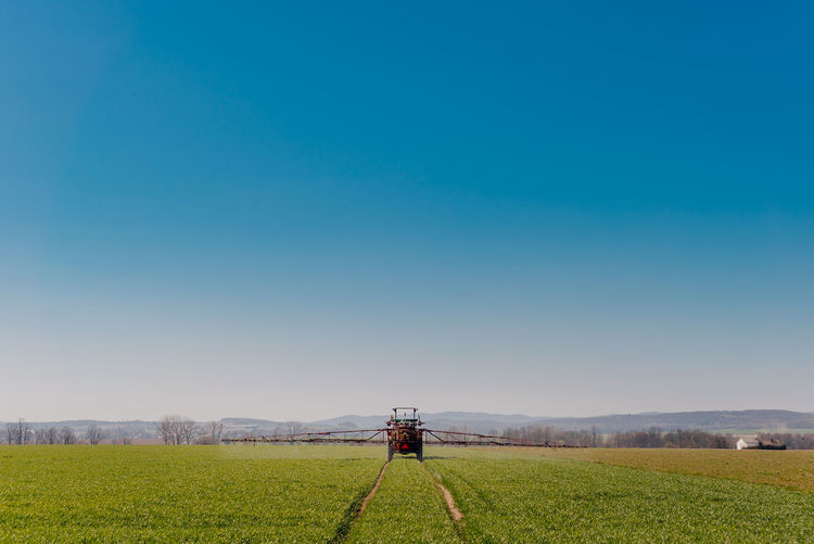 Scenic view of agricultural field against blue sky