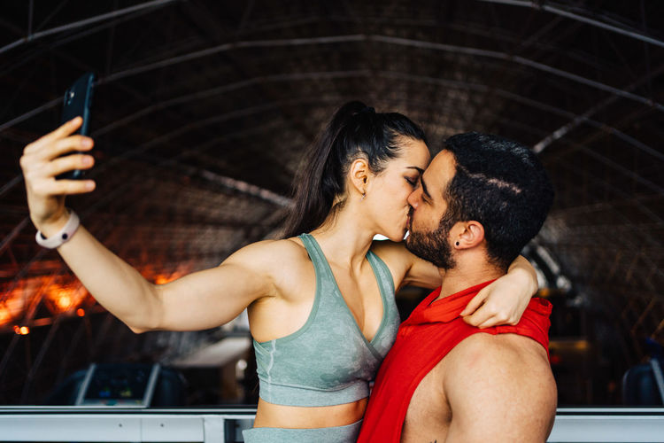 Portrait of young couple in love having a special moment in gym clothes taking a photo