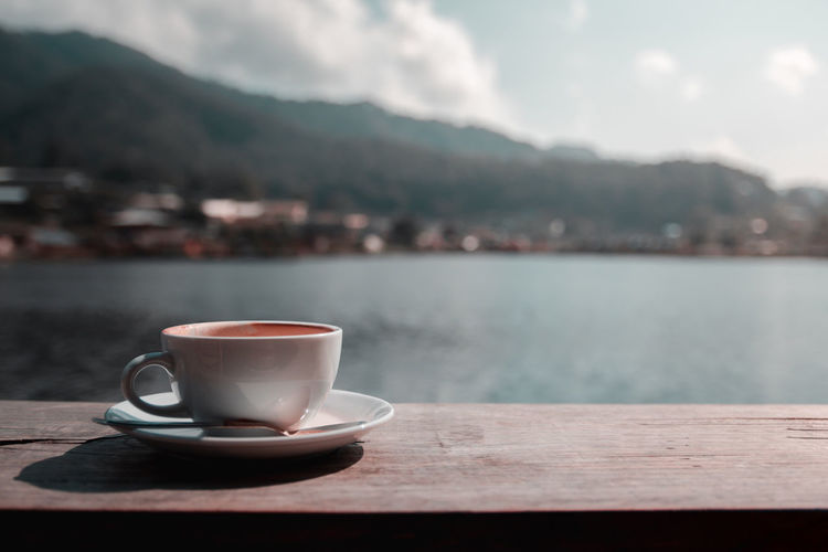 Close-up of coffee on table against mountains