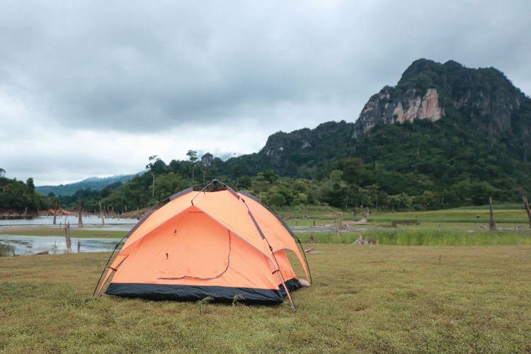 Tent on field by mountain against sky