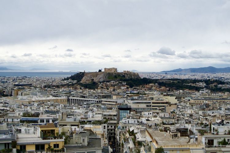 View of cityscape against cloudy sky